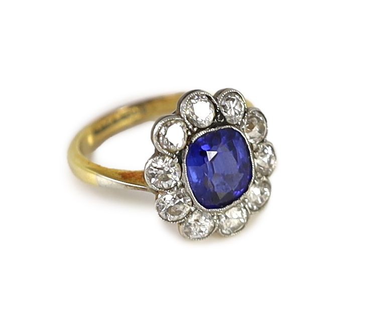 An 18ct gold and platinum, synthetic sapphire and diamond set oval cluster ring